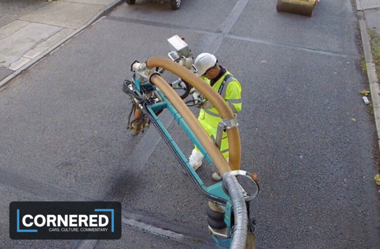 Road worker using a pothole repair machine on a residential street